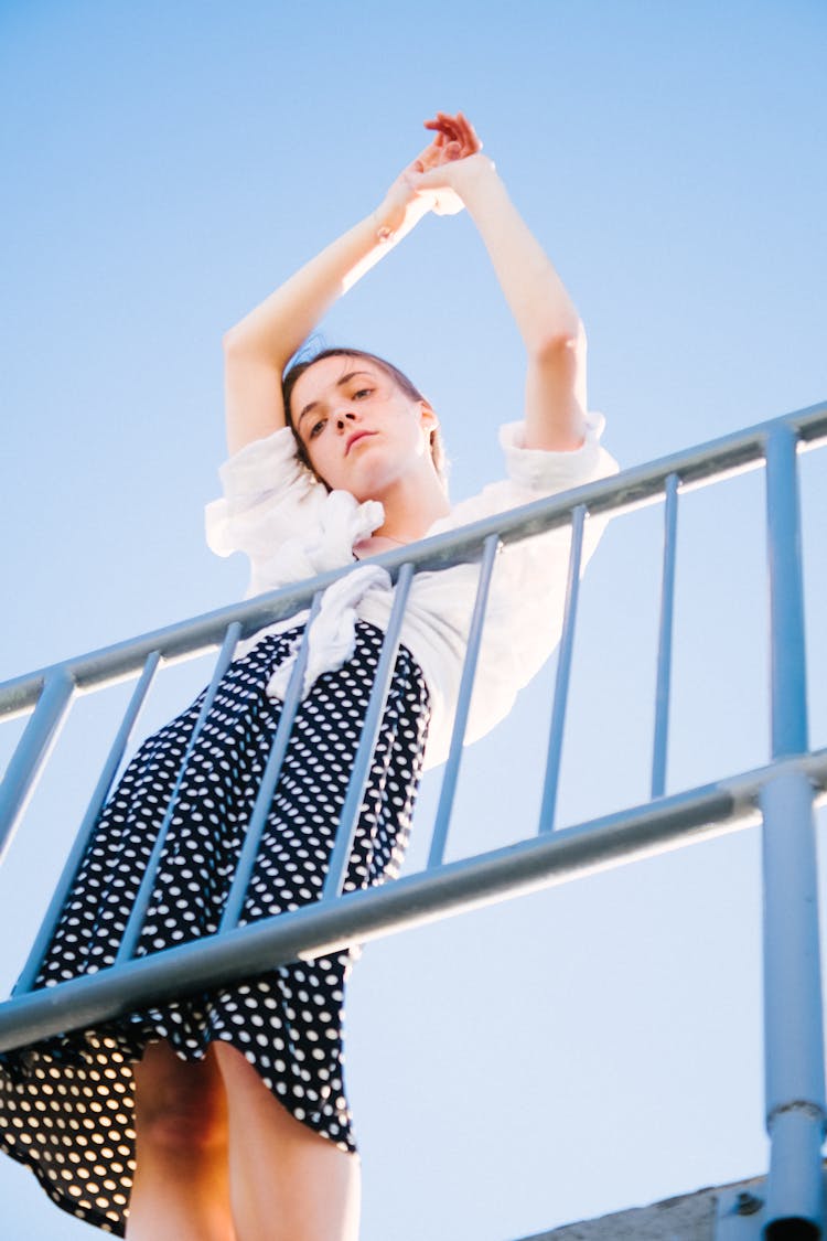 Woman Wearing A White Top And Polka Dot Skirt