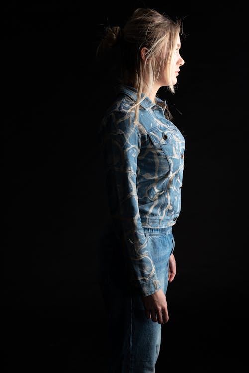 A Side View of a Woman in Denim Jacket and Denim Pants