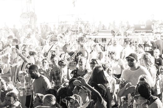 Black and white photo of a diverse crowd enjoying a lively festival atmosphere.