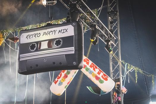 Hanging retro cassette and Love Hearts decorations at a vibrant music festival stage.