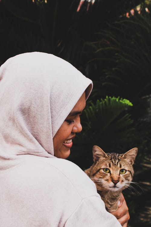 Smiling Woman with Tabby Cat in Her Arms