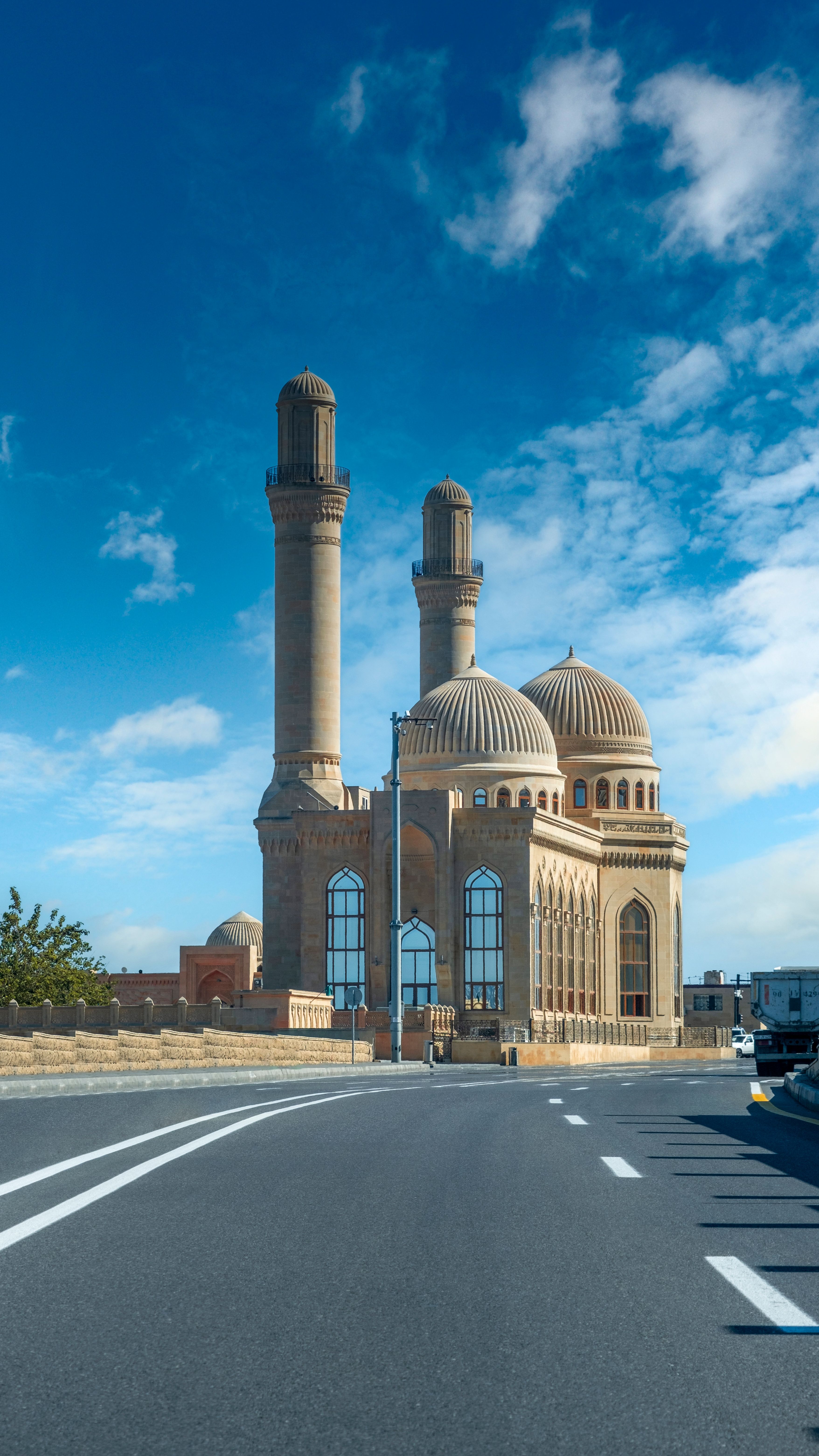Bibi Heybat Mosque in Baku, Azerbaijan, with its iconic domes and minarets against a bright blue sky.