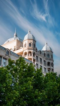 A stunning view of an elegant building with domes and a classic facade against a clear blue sky.