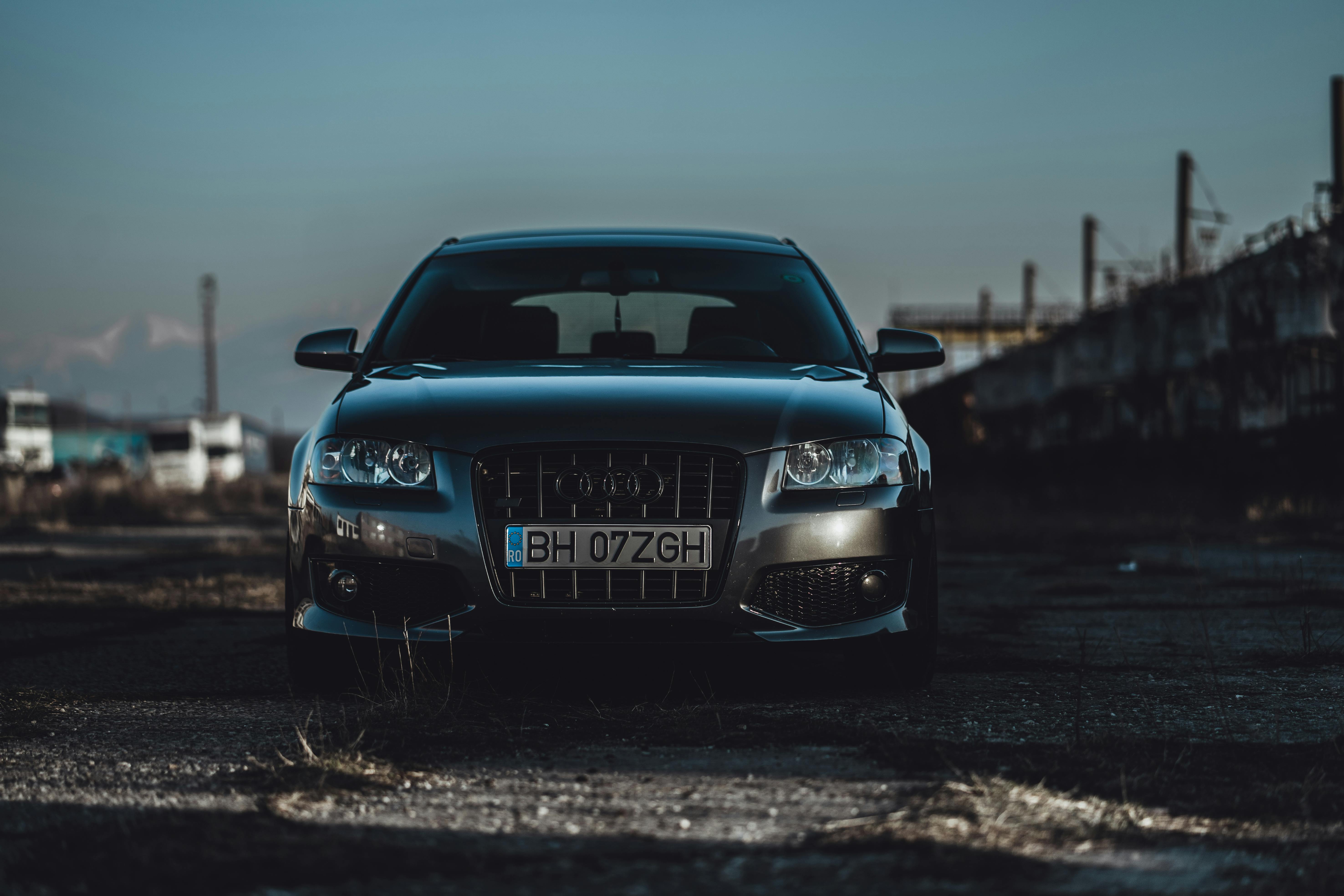 A stylish vehicle parked in a gritty industrial district during the day.