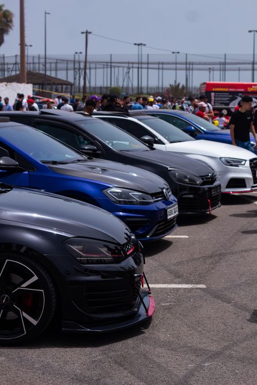 Free Several sleek luxury sedans parked in a row at an outdoor automotive event. Stock Photo