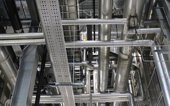 Vertical shot of steel pipes and ventilation in an industrial setting.