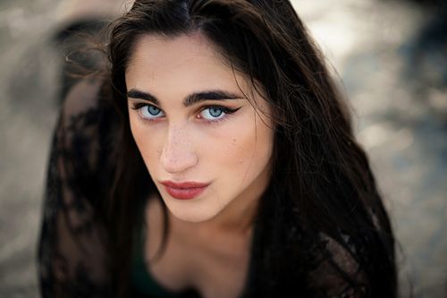 Free Close-up outdoor portrait of a woman with piercing blue eyes and dark hair. Stock Photo
