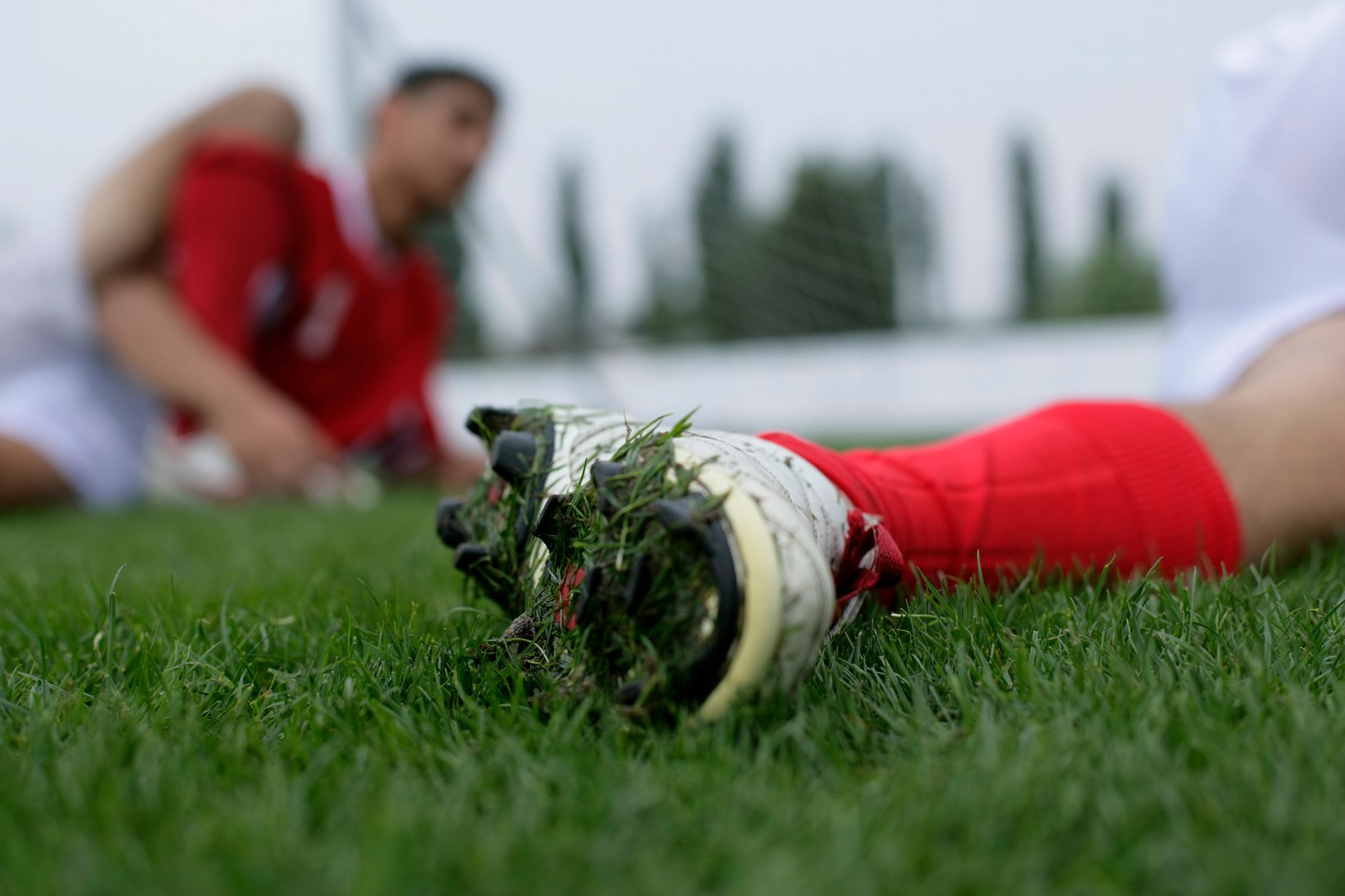 close-up of FG and AG football cleat stud patterns resting on grass and artificial turf
