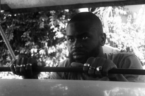 A Grayscale Photo of a Man Wearing Silver Rings