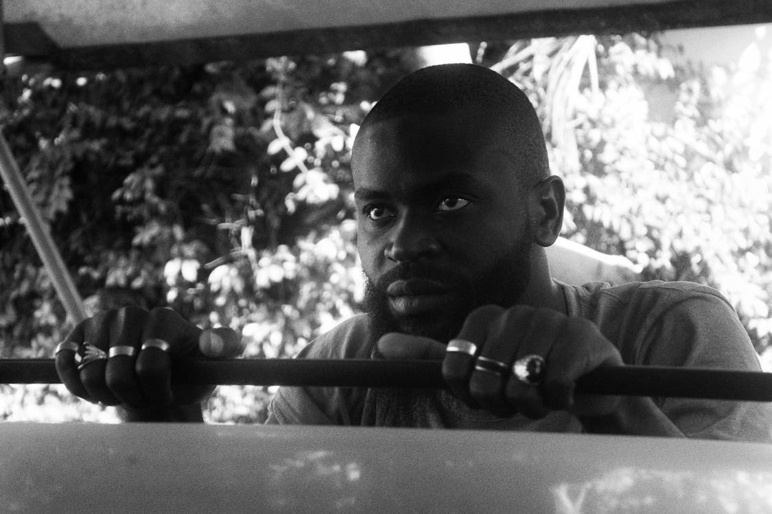 A Grayscale Photo of a Man Wearing Silver Rings