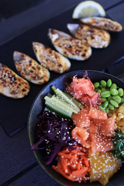 Salmon Sashimi with Sliced Vegetables on Black Ceramic Bowl