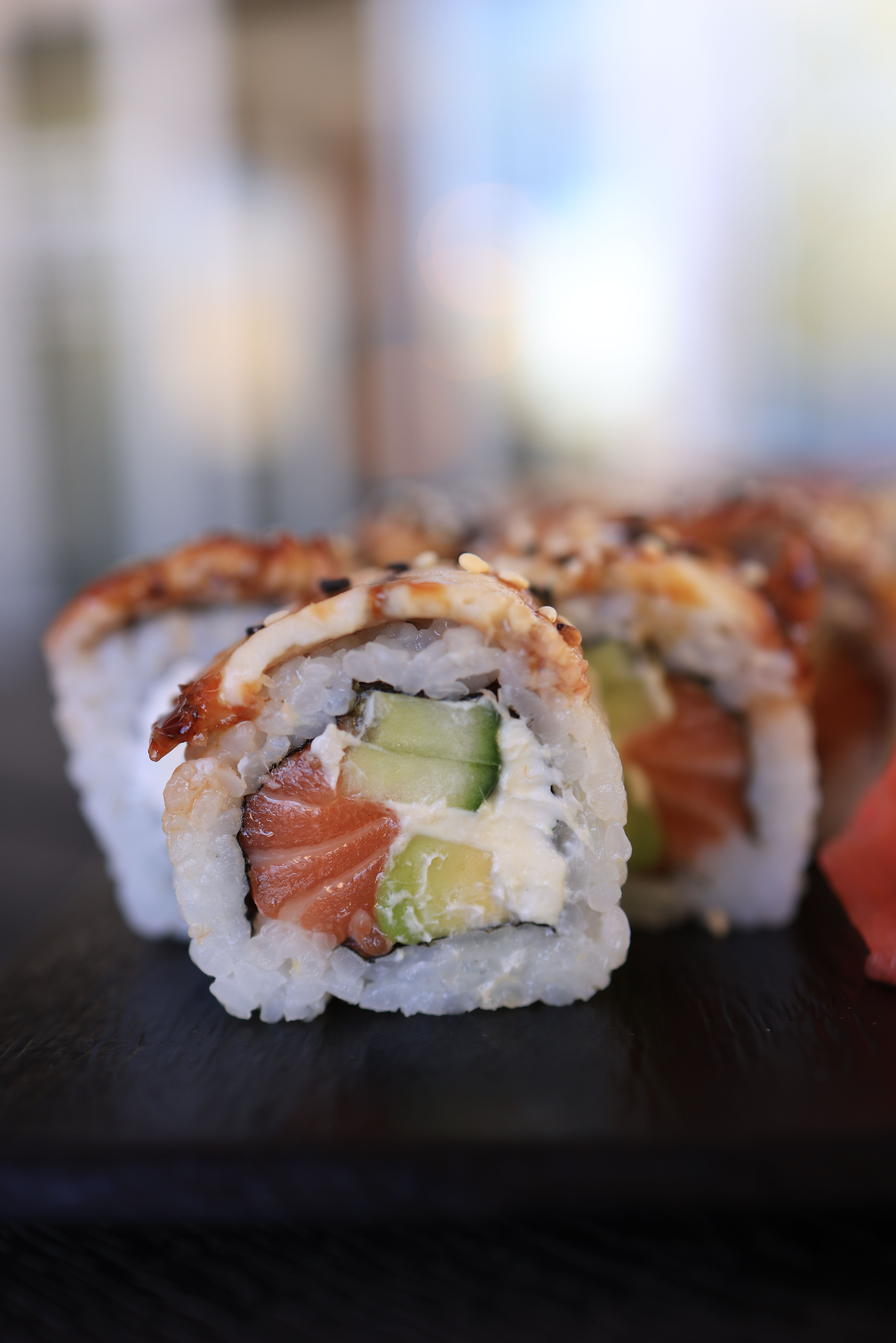 Close-up view of sushi rolls with salmon, avocado, and cream cheese. Perfect for food enthusiasts.