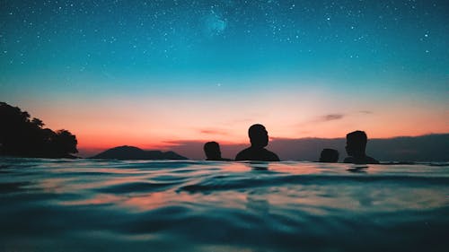 Free Silhouette of People on Water during Dusk Stock Photo