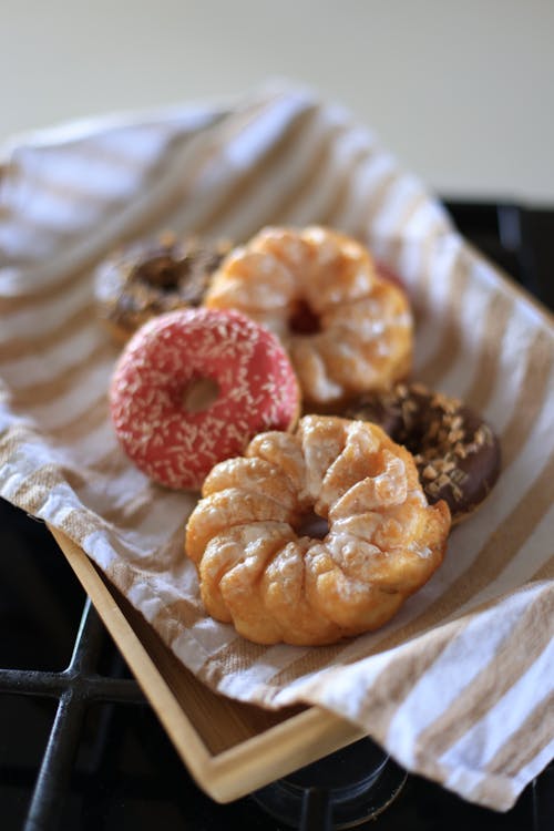 Doughnuts on a Wooden Plate with Beige and White Striped Cloth
