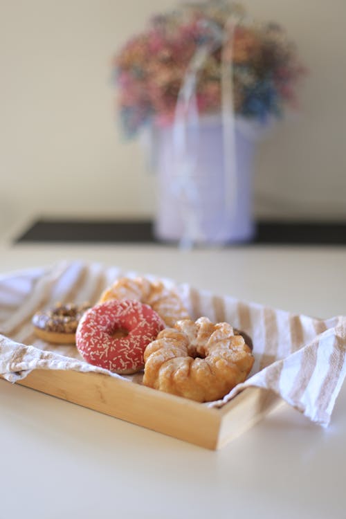 Doughnuts on a Wooden Plate with Beige and White Striped Cloth