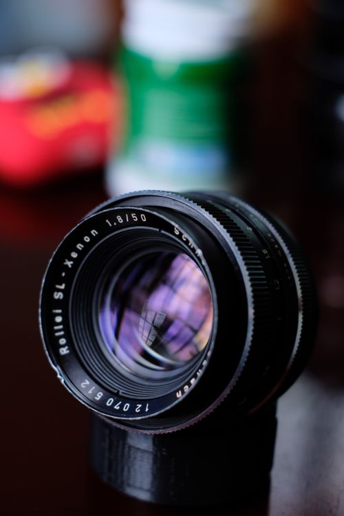 Free A detailed close-up shot of a vintage Rollei SL Xenon camera lens with colorful reflections. Stock Photo