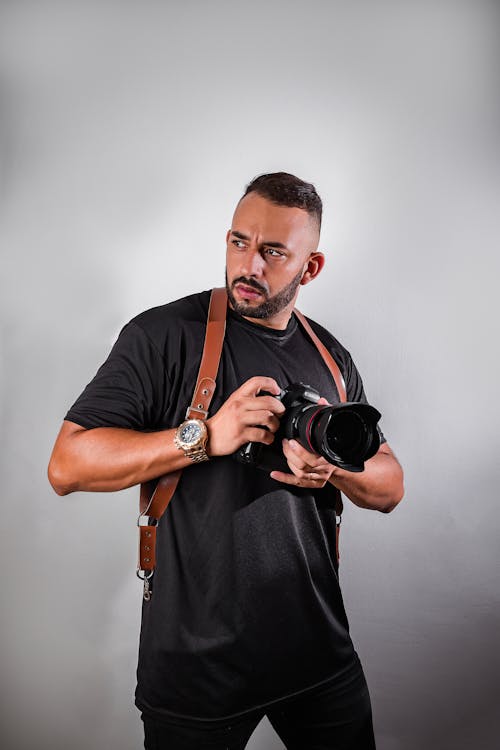 Studio Portrait of a Photographer Holding His Camera 