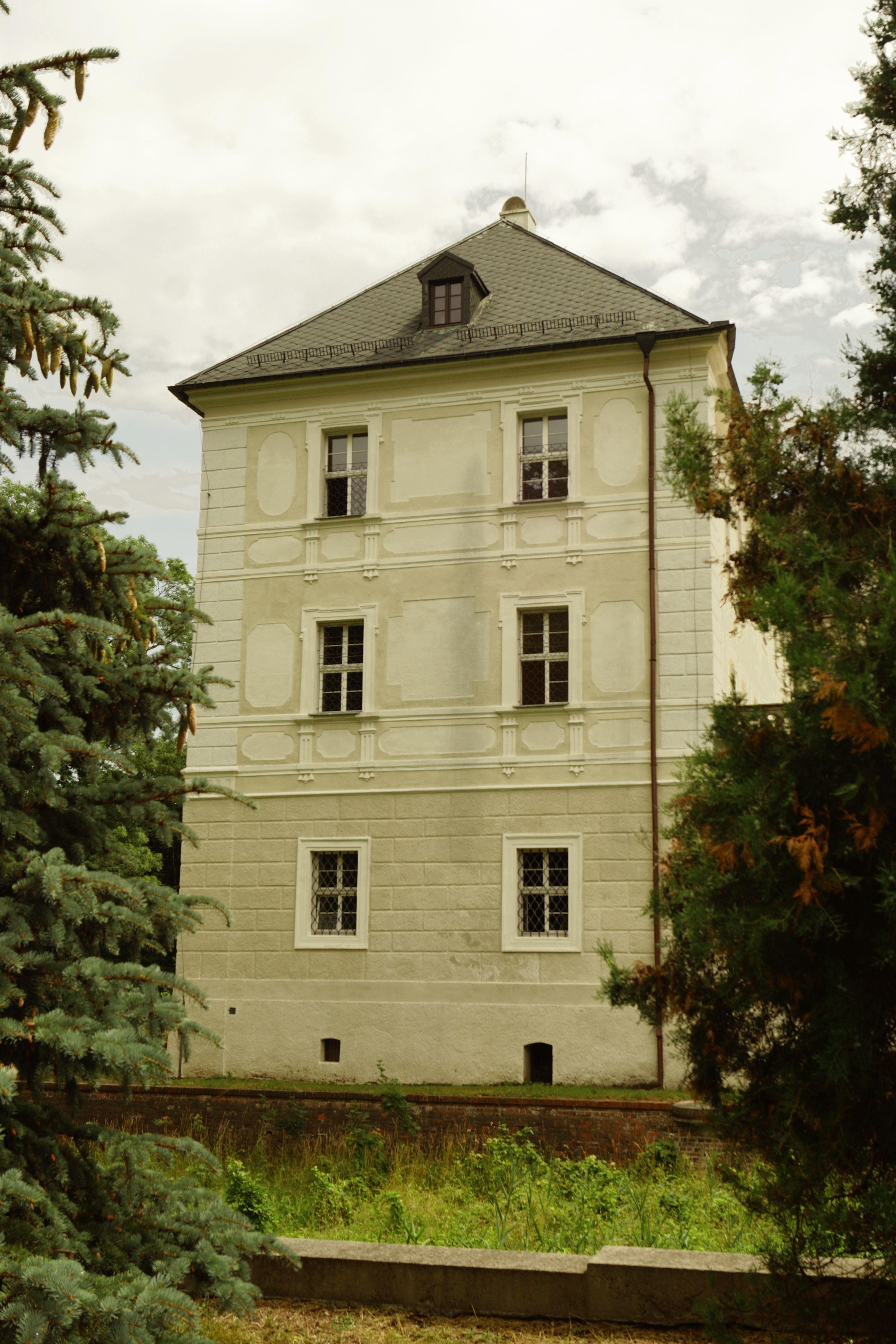 A White House with Roof Tiles Between Green Trees · Free Stock Photo