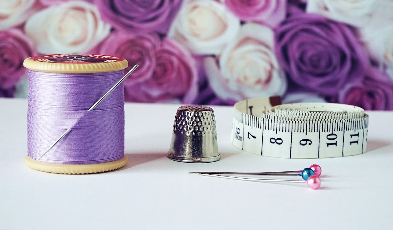 Free Spool of Purple Thread Near Needle Thimble and Measuring Tape Stock Photo