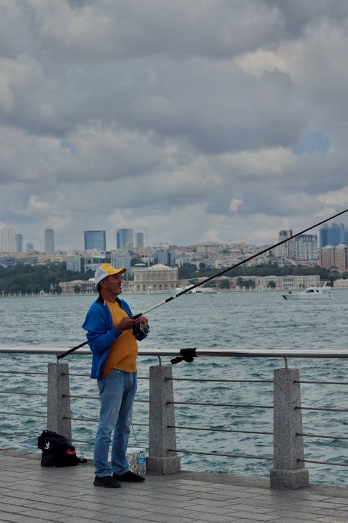 adam, ayakta, Balık tutmak içeren Ücretsiz stok fotoğraf