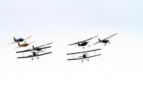Free 7 Biplane Flying on Air Under Clouds during Daytime Stock Photo