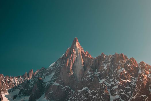 Breathtaking view of the Aiguille du Dru in the French Alps under a clear sky.