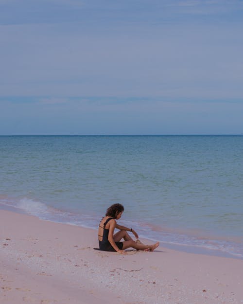 Free Woman in Swimsuit Sitting on Beach Shore Stock Photo