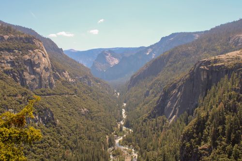 Free Breathtaking aerial view of Yosemite Valley with lush forests and towering mountains under a clear blue sky. Stock Photo