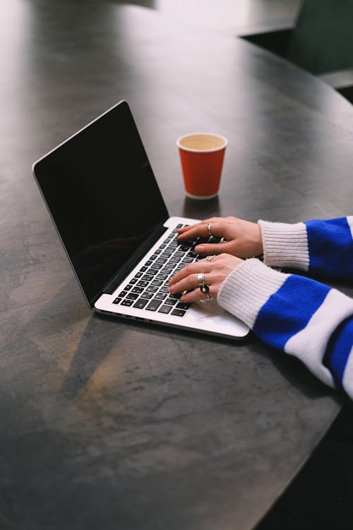 Hands Wearing Striped Sweater Working on Laptop