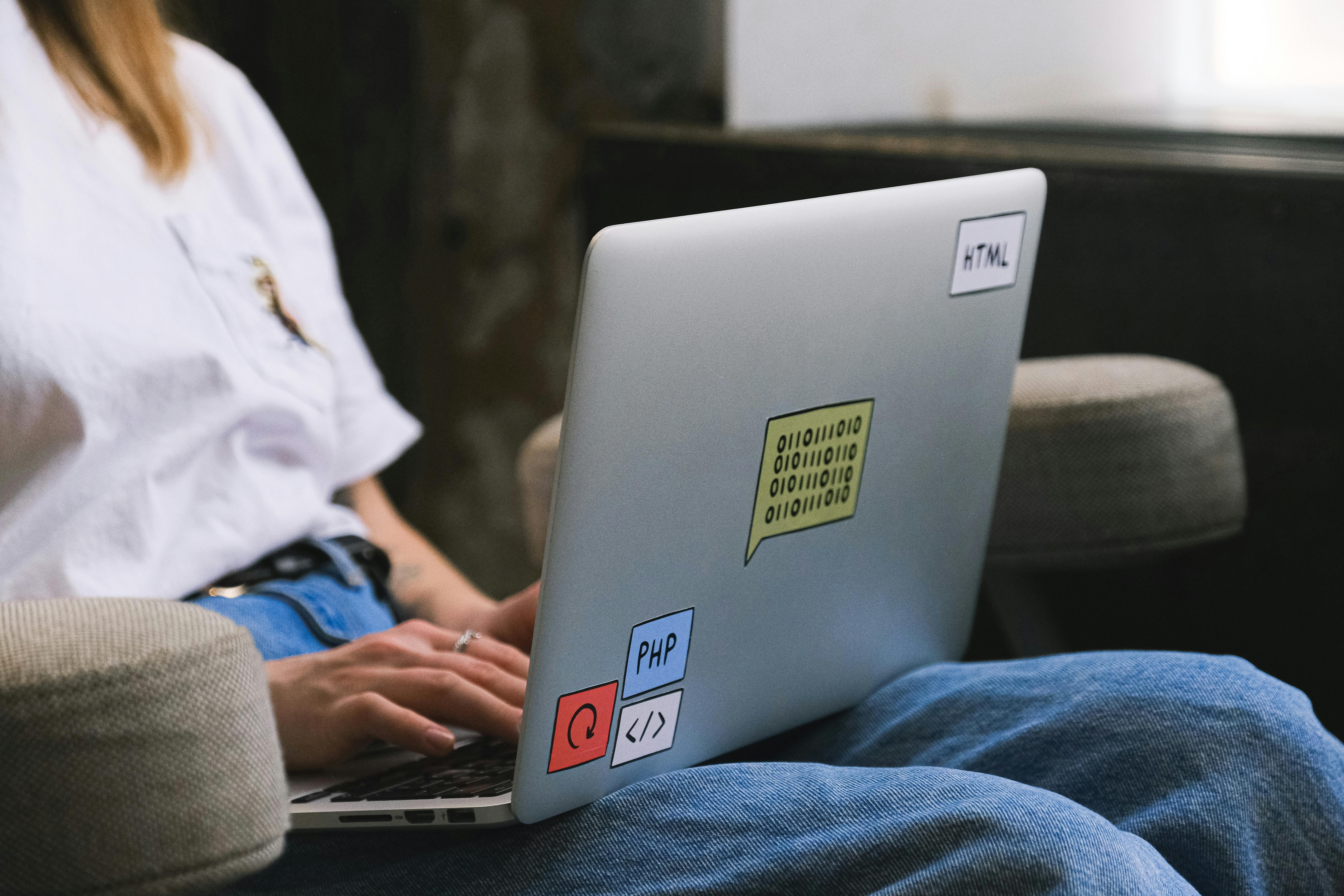 person in blue denim jeans using a laptop