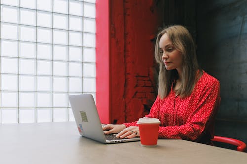 A Woman in Red Long Sleeves using a Laptop