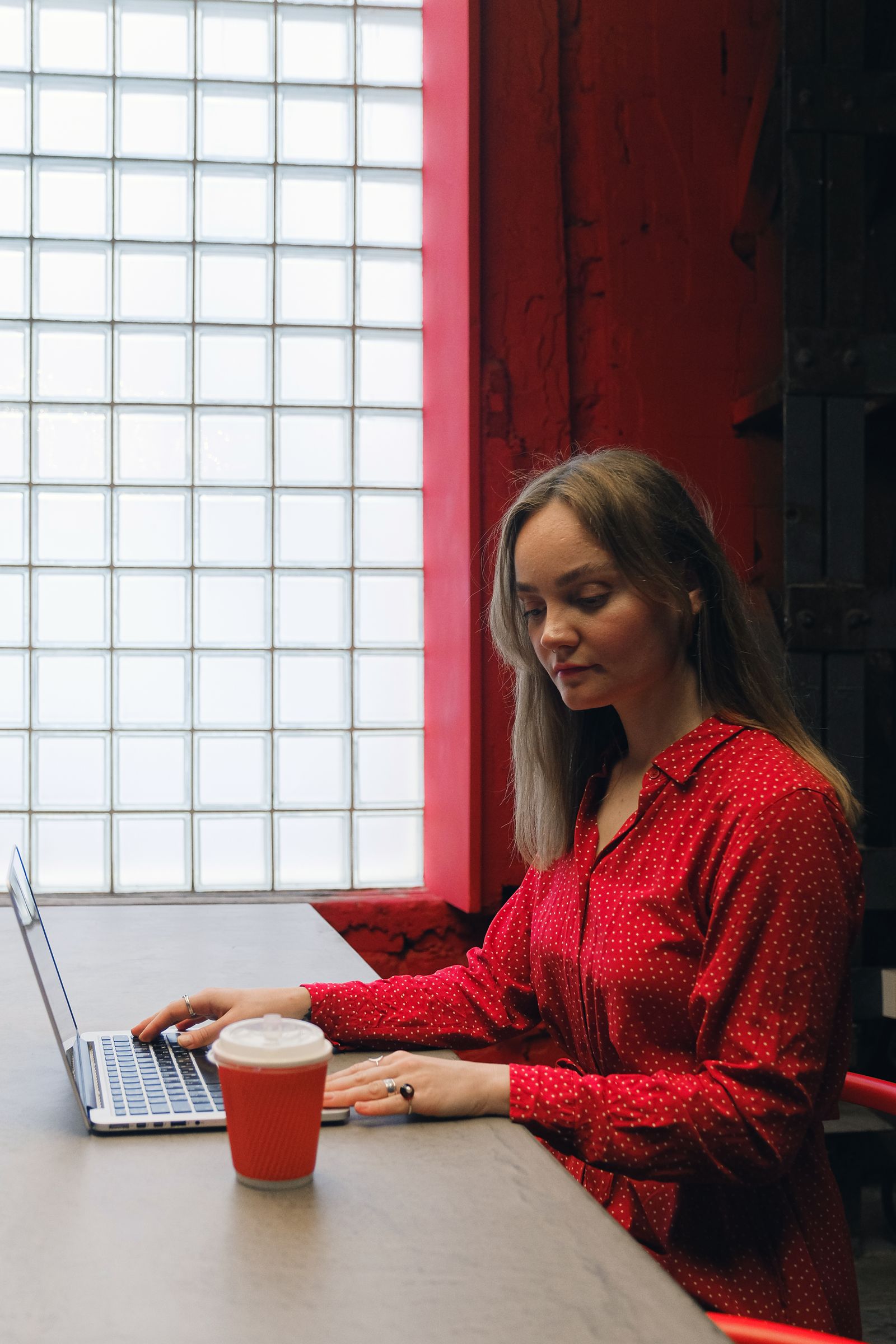 A designer at a laptop in a studio with red walls