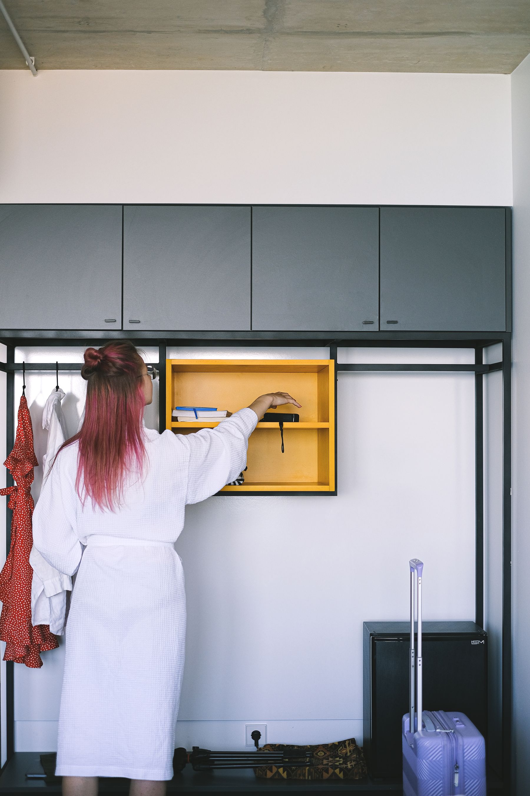 Traveler organizing an open suitcase in a bright modern hotel room