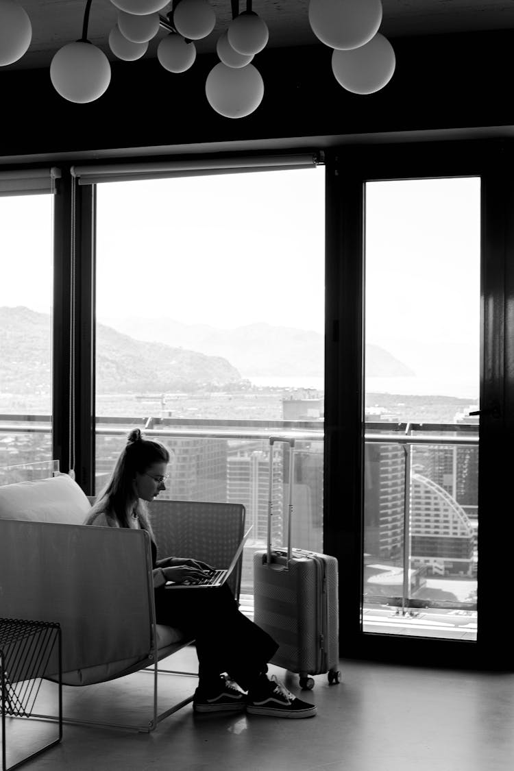 Black And White Photo Of A Woman Using A Laptop On The Sofa