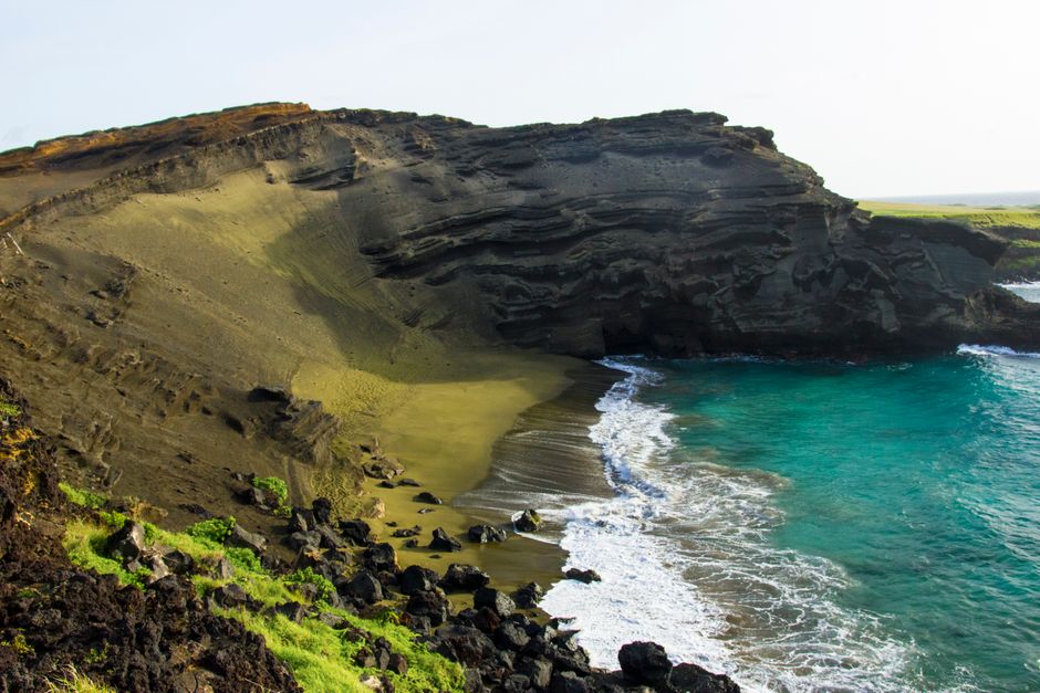 Scenic view of Papakōlea Beach with unique green sand and vibrant blue waters in Hawaii.