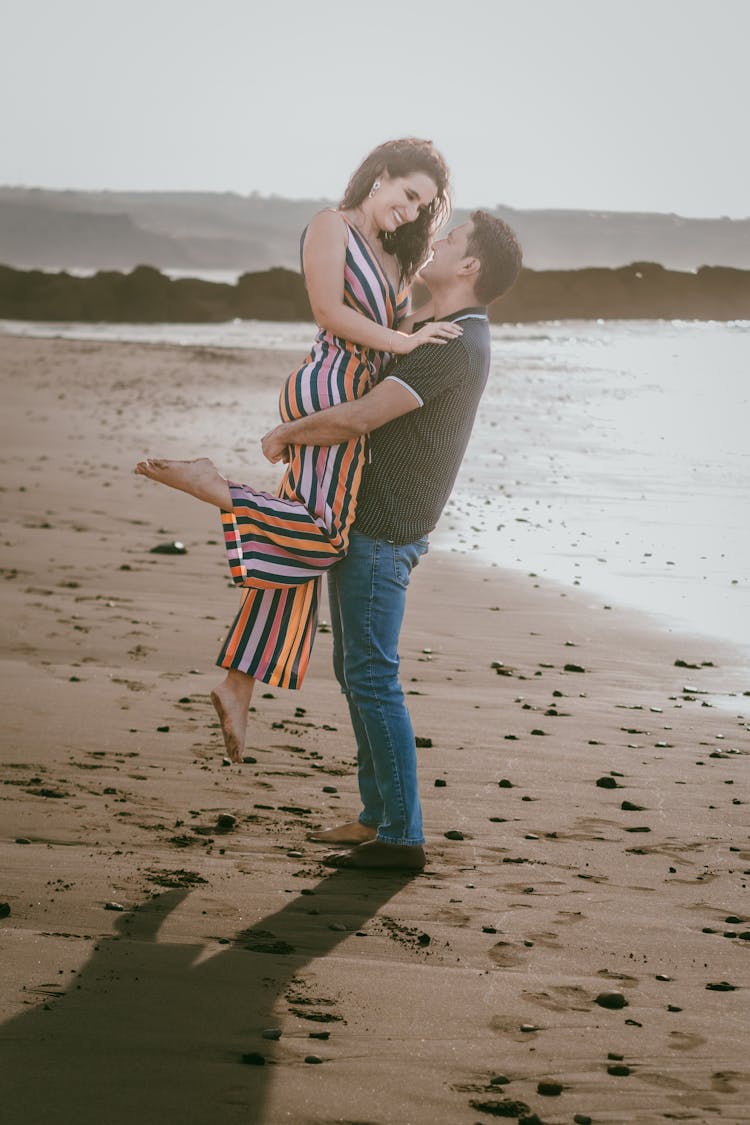 Man Carrying A Woman At The Beach