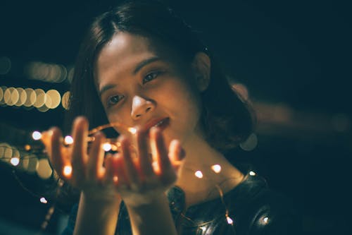 Close-Up Photography of Woman Holding String Lights