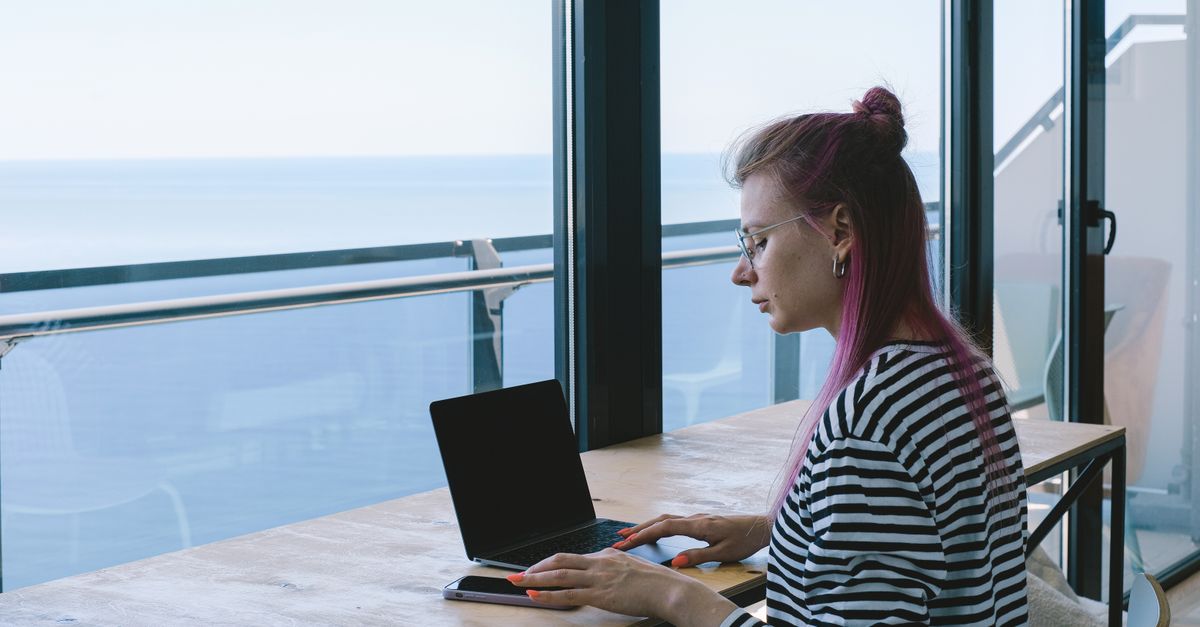 Digital nomad working on laptop with ocean view in Zanzibar