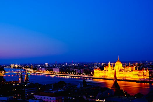 A breathtaking night view of the illuminated Hungarian Parliament on the Danube River in Budapest.