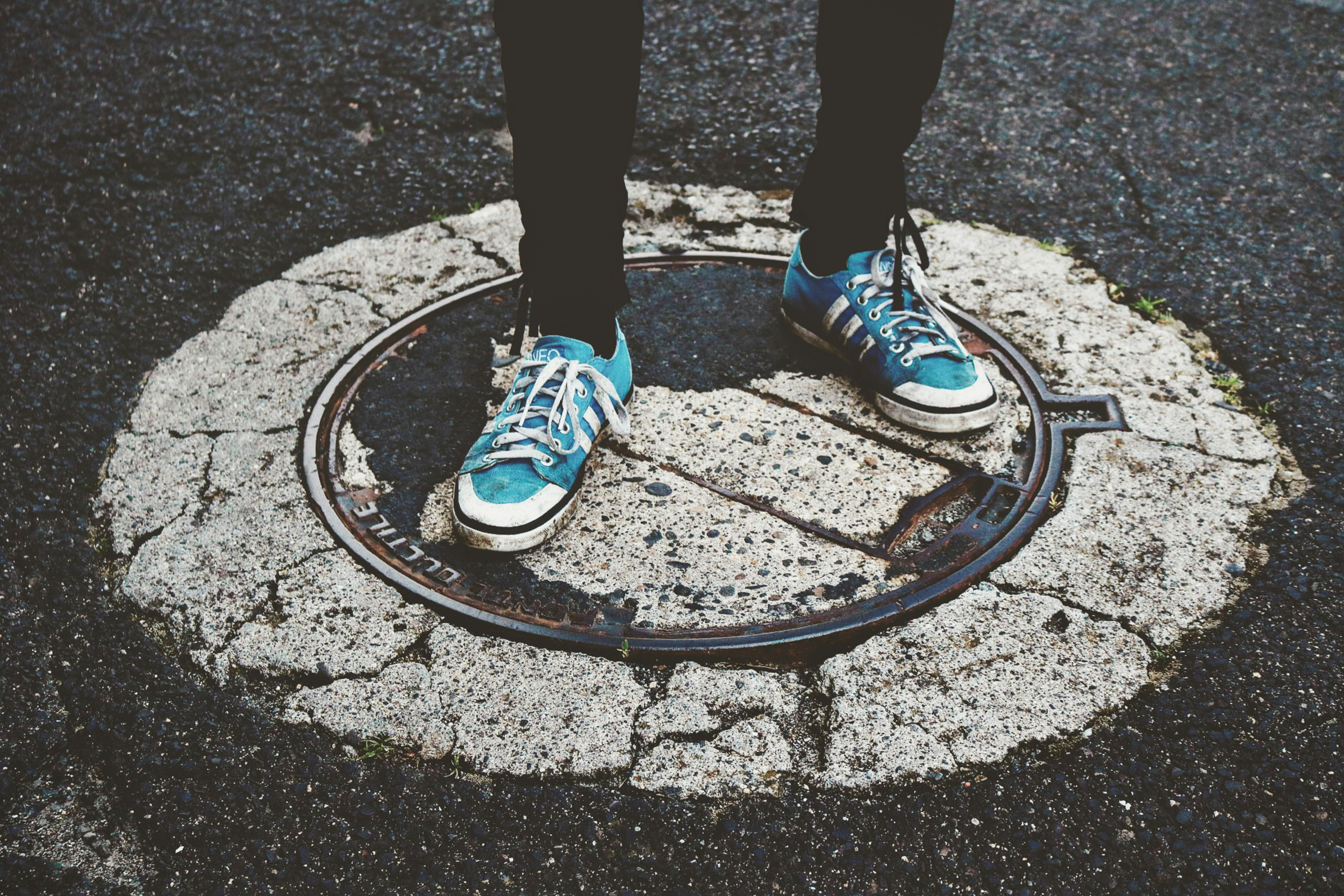 person standing on manhole cover