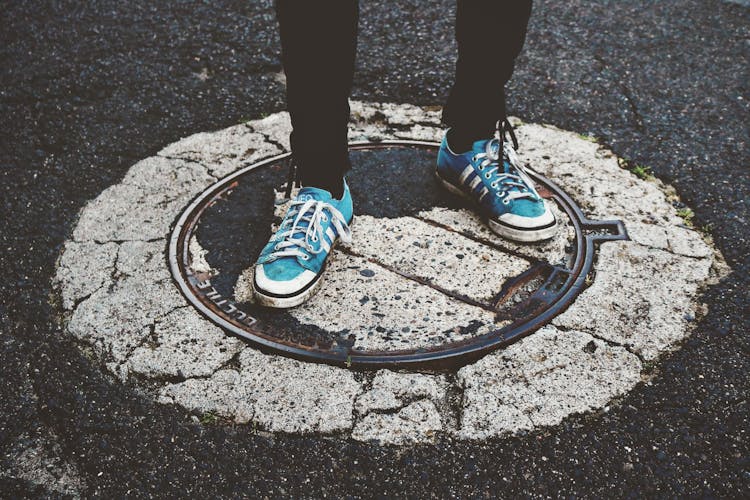 Person Standing On Manhole Cover