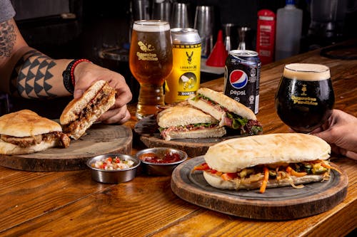 Free Sandwiches and Beers on Wooden Table Stock Photo