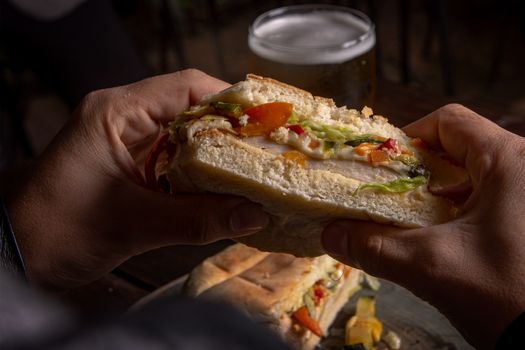 A fresh sandwich with crispy vegetables held by hands, ready for a tasty bite.