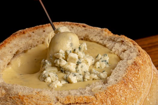 Close-up of creamy blue cheese fondue in a homemade bread bowl. Perfect comfort food.