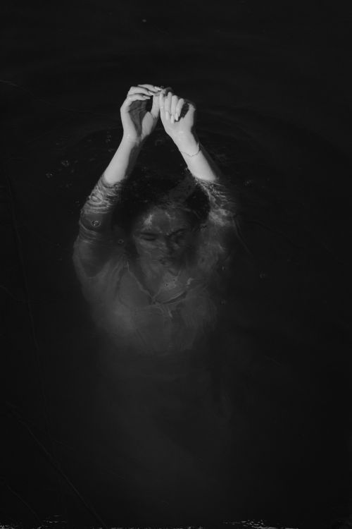 Free Ethereal image of a woman submerged underwater in black and white, creating a mysterious and artistic mood. Stock Photo