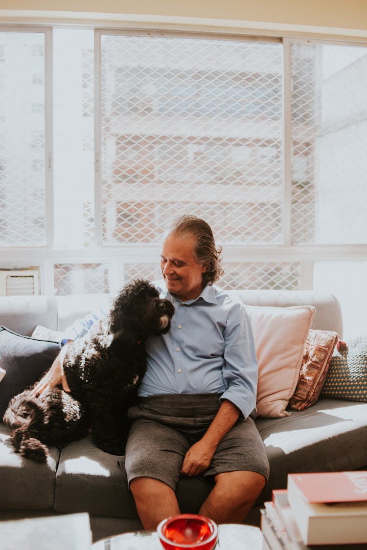 Man Sitting On A Sofa With A Dog