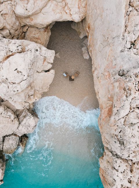 Breathtaking aerial view of a secluded beach surrounded by rocky cliffs in Kaş, Turkey.