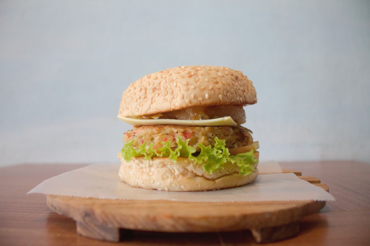 close up of a homemade cheeseburger with fresh lettuce and cheese on a