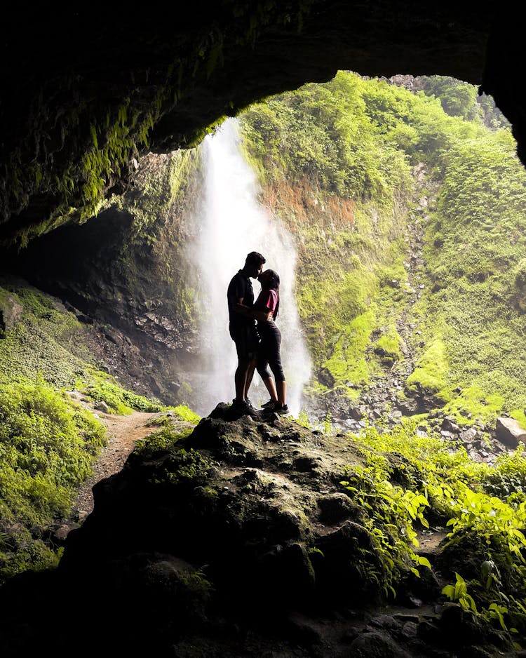 Kissing Couple Against Waterfall