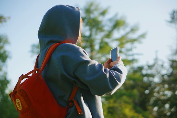 Person Wearing Hoodie Taking Photo